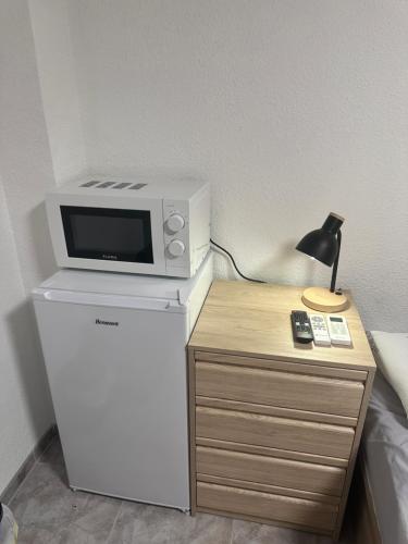 a microwave on top of a refrigerator next to a table at TAJ ROOM center altea #D in Altea