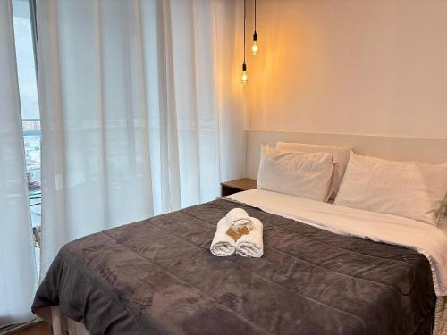 a bed with a pair of shoes sitting on it at HLB_1006- Studio Completo com Vaga | Próx. GRU in Guarulhos