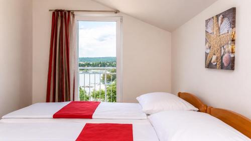 a bedroom with a bed and a large window at Mare & Mons Seafront Apartments in Malinska