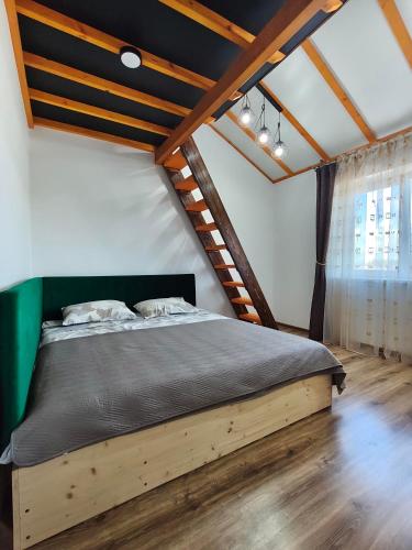 a bedroom with a wooden bed in a attic at Zeigių apartamentai in Normantai