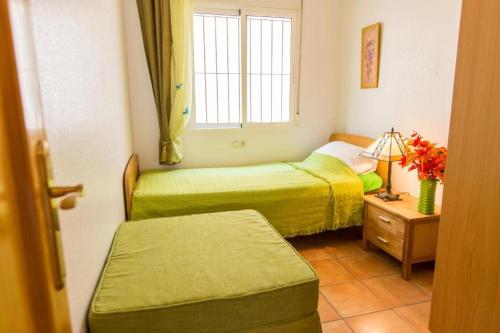 a small room with two beds and a window at Oriheula Costa Cabo Roig 5 in Playas de Orihuela