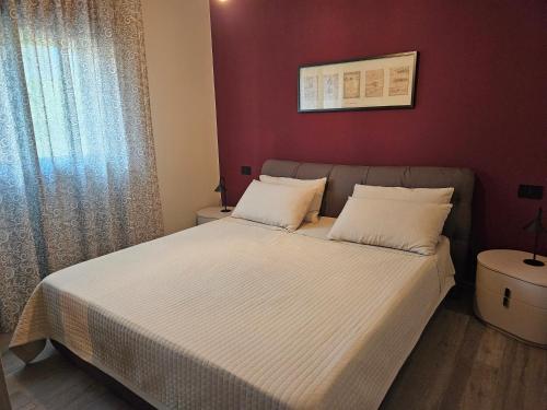 a bed in a bedroom with a red wall at EdenGHouse in Cordenons