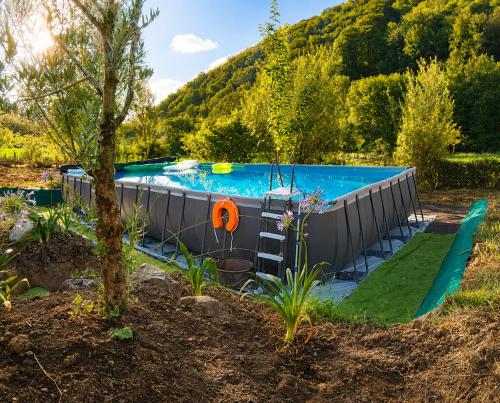 a swimming pool in the middle of a garden at Coume a Case - Maison de charme 4 étoiles - piscine et spa - vallée d'Ossau in Lys
