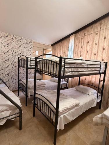 three bunk beds in a room with a wall at M&W Hostel in Yerevan