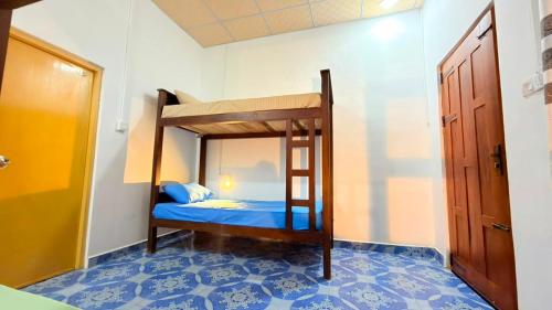 a bunk bed in a room with a blue floor at Coral Moon in Trincomalee