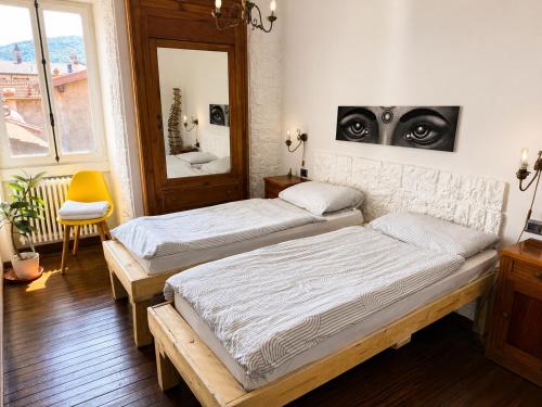 two beds in a room with a mirror at Monastero Retreat - Villa con SPA in Lanzo dʼIntelvi