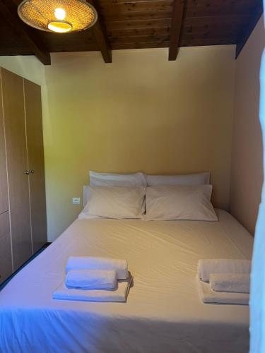 a bed in a room with two towels on it at Amarynthos Tiny Retreat in Amarynthos