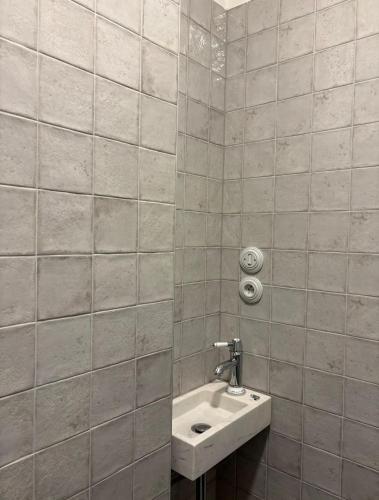 a bathroom with a sink and a tiled wall at Monte-Rosa in Karlovy Vary