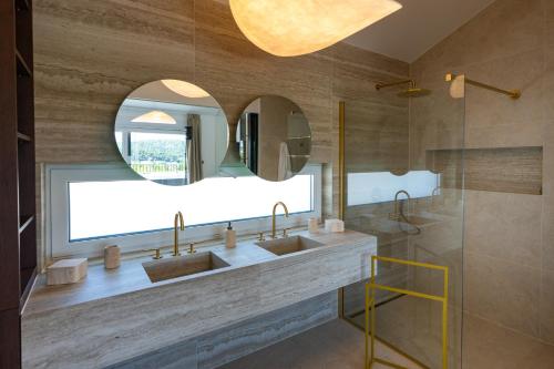 a bathroom with two sinks and a mirror at Villa Loparia in Lopar