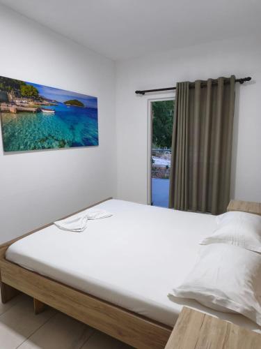 a bedroom with a large bed with a window at Rezidenca Nanaj in Vlorë