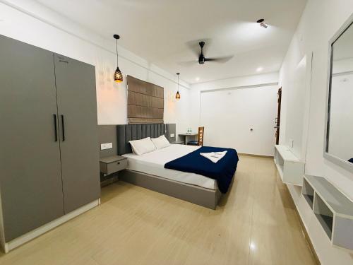a bedroom with a bed with a blue blanket at Lowfare Hotels Bengaluru in Bangalore
