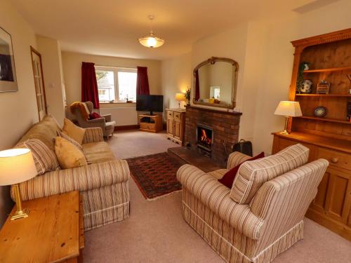 a living room with two couches and a fireplace at Sarah's Cottage in Berwick-Upon-Tweed