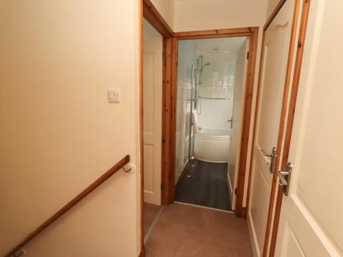 a hallway with a door leading to a bathroom at Sarah's Cottage in Berwick-Upon-Tweed