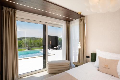 a hotel room with a bed and a view of a pool at Villa Loparia in Lopar