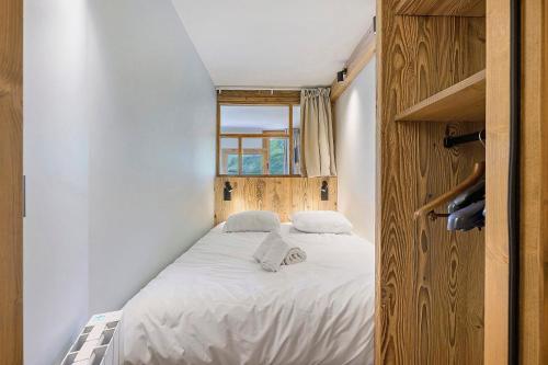a small bed in a room with a window at Appartement Le Panorama Des Pistes in Les Menuires