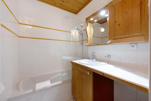 a bathroom with a sink and a bath tub at Appartement Airelles B25 in Levassaix