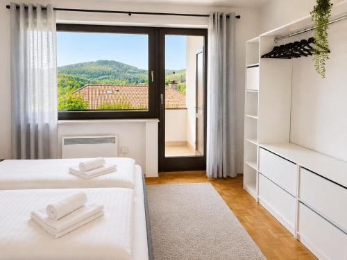 a bedroom with two beds and a large window at Ferienwohnung Seeblick 24 in Winterberg