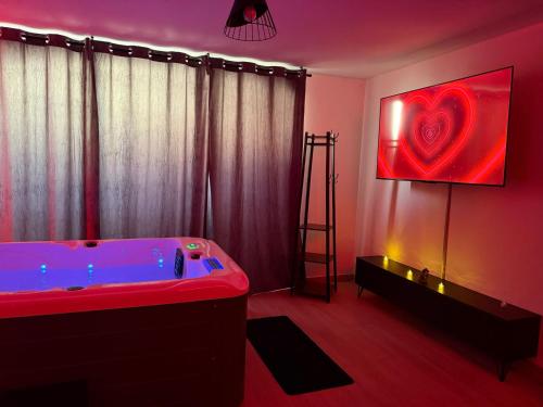 a bathroom with a tub with a red heart on the wall at Love Room Emoi de toi in Sigean