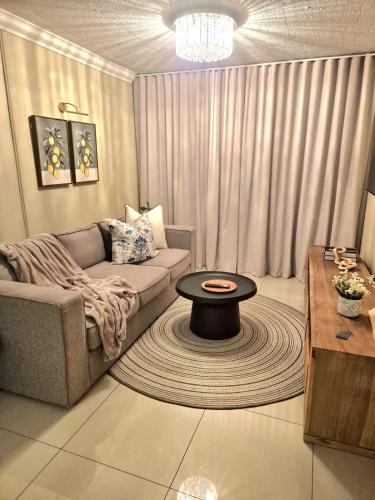 a living room with a couch and a table at Fortune Lux - Tygerwaterfront in Tyger Valley