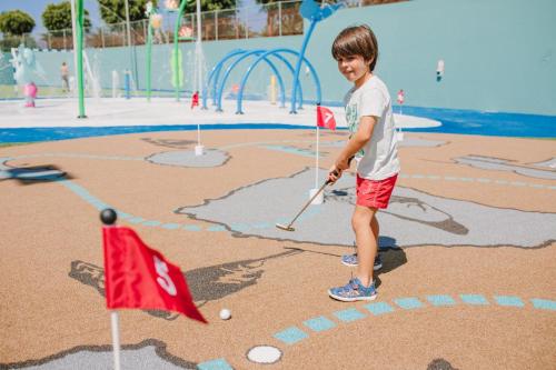 a young boy playing golf in a playground at Maspalomas Resort by Dunas in Maspalomas