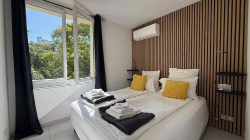 a bedroom with a bed with towels on it at Kimi Résidence in Cannes