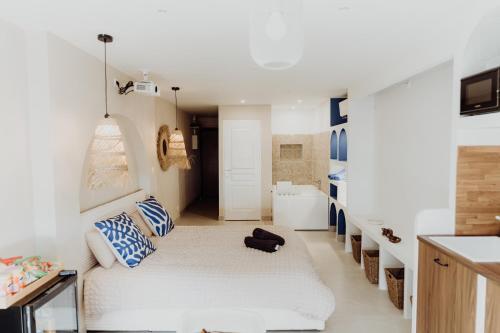 a white room with a bed and a bathroom at Suite Katalanos & Spa in Le Barcarès