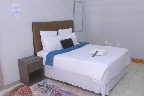 a bedroom with a large white bed with a blue blanket at Fargon Guest House in Polokwane