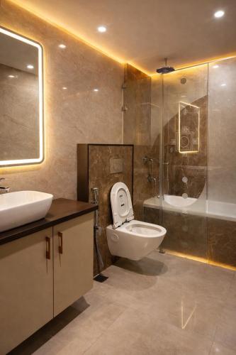 a bathroom with a toilet and a sink and a tub at Atlantiis Suites Inn By Signature Stays Near Vishwanath Temple Rathyatra in Kakarmatha