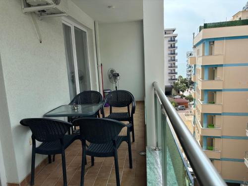 a balcony with a table and chairs on a balcony at Sea & Mount apartament in Shëngjin