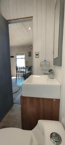 a bathroom with a sink and a table with chairs at Cabaña Luna de Lobos in Pichilemu