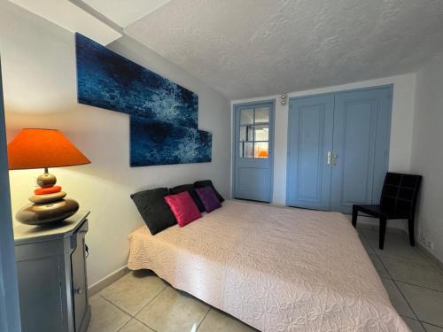 a bedroom with a bed and a table with a lamp at Chez Antoinette et Jo in Drap