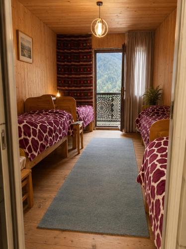a room with two beds and a large window at Stone House marexi in Adishi
