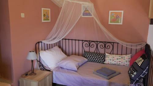 a small bedroom with a bed with a canopy at Alba Andros Traditional Villa in Andros