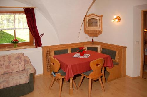 ein Esszimmer mit einem roten Tisch und Stühlen in der Unterkunft Vilahof in St. Vigil