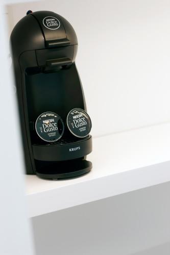a black coffee maker sitting on a shelf at Quinta Do Miguel in Aldeia do Meco