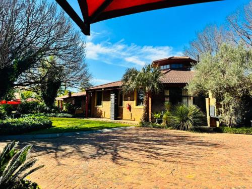 a house with a driveway in front of it at Kriel Windpomp Guesthouse in Aangewysd