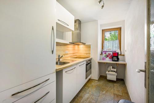 a kitchen with white cabinets and a sink at Ferienwohnung Sophie in Ruhpolding