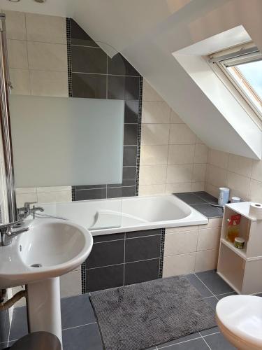 a bathroom with a sink and a bath tub at L'Atelier - Grande chambre d'hôtes in Caen