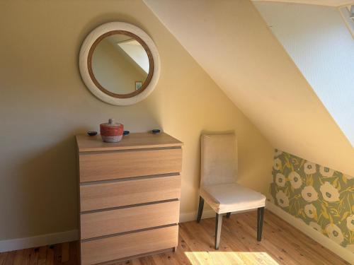 a bedroom with a dresser and a mirror and a chair at L'Atelier - Grande chambre d'hôtes in Caen
