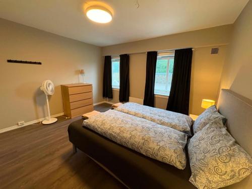 a bedroom with a bed and a dresser and windows at Notodden Sentrum Apartment NO 14 in Notodden