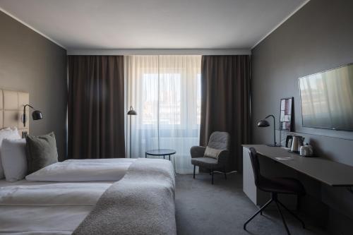 a hotel room with a bed and a desk at Clarion Hotel Gillet in Uppsala