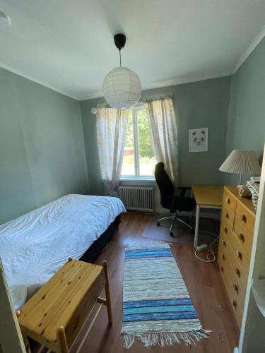 a bedroom with a bed and a desk and a window at 5ans rum in Skellefteå