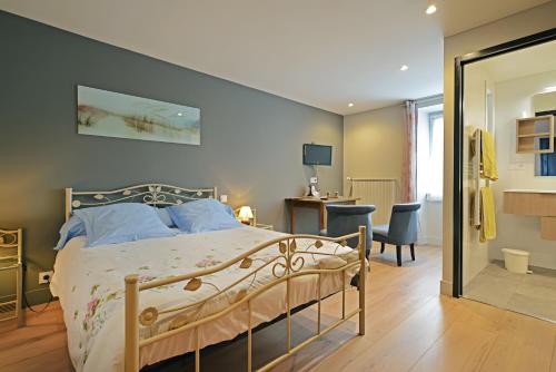 a bedroom with a bed and a desk and a mirror at Chambres D'hôtes Le Sahut in Castelnau-Pégayrols