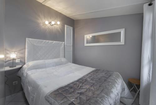 a white bedroom with a large bed and a sink at Le Petit Mas - Piscine Clim in Grillon