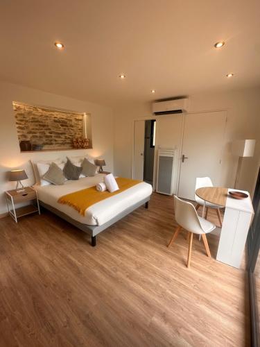 a bedroom with a large bed and a table at Lo Coustil in Saint-Martin-Labouval