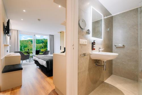 a bathroom with a sink and a bedroom with a bed at Hotel - Appartement de Zevende Heerlijkheid in Slenaken