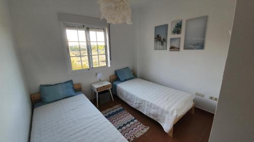 a room with two beds and a window at Sun And Moon in Ayamonte