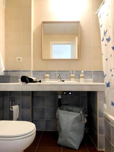 a bathroom with a sink and a toilet and a mirror at Sun And Moon in Ayamonte