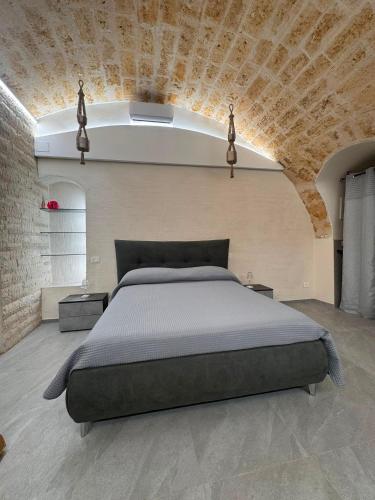 a bedroom with a bed and a brick wall at Twins Luxury Suite - Barletta in Barletta