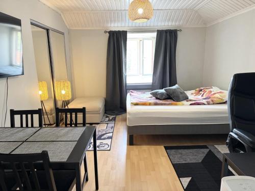 a small room with a bed and a dining table at Rautatien ullakkohuoneisto in Karkkila